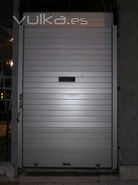 Puerta enrollable de aluminio COLLBAIX con ventana reducida para guardias de farmacia