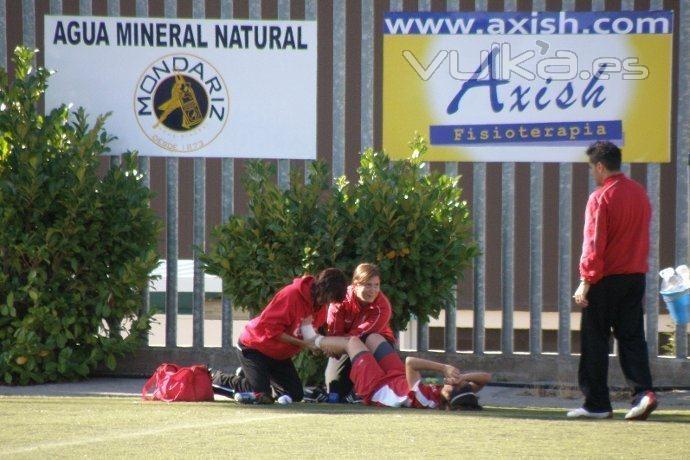 Fisioterapeuta de Axish atendiendo a una jugadora de fútbol