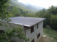 casa con muros de caraga de hormigón y tejado de zinc