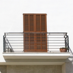 Balcon de hierro pintado de negro con barillas horizontales, con pasamanos de inox