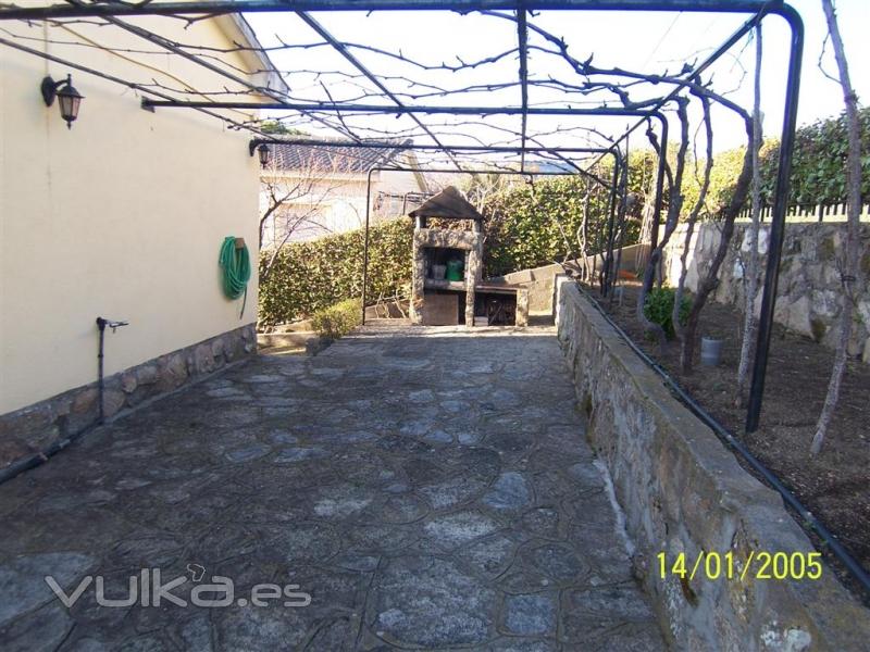 IMAGEN DE EL PASILLO LATERAL SOLADO EN PIEDRA Y EN EL FONDO LA BARBACOA