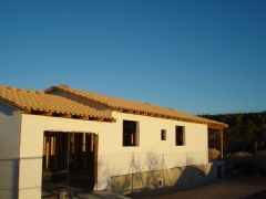 Casa de madera vista lateral en canexel blanco y cochera adosada