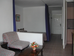 Vista apartamento salon con sofa cama y dos camas separadas del saln por cortina