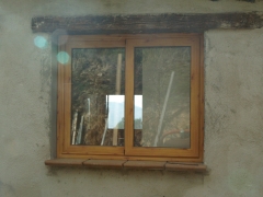 Ventana corredera, de aluminio imitacin madera, colocada en una casa de campo