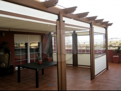 Pergola en aluminio imitacion madera y toldos bajantes para poder cerrar un trozo de la terraza