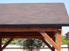 Porche de madera laminada en pino abeto con tela asfaltica imitacion teja pizarra.