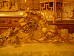 Detalle de copete de un sof de sillera louis-xv en madera tallada y sobredorada.