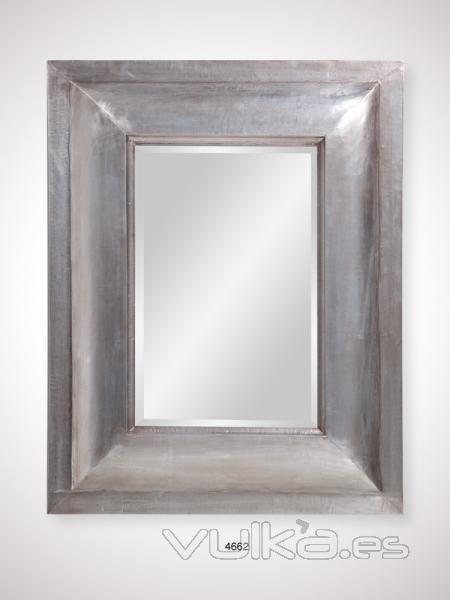 Espejo con marco de madera en tono plata.