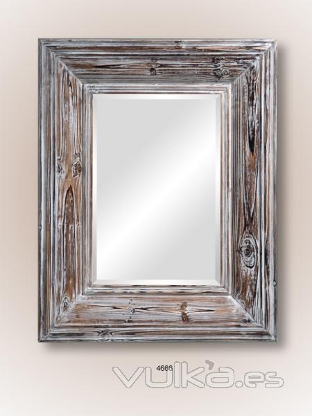 Espejo de pared con marco de madera natural decapada.