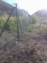 Cercado formado por malla st plast instalda en postes lacados en verdes