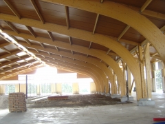 Nave con pórticos curvos en madera laminada