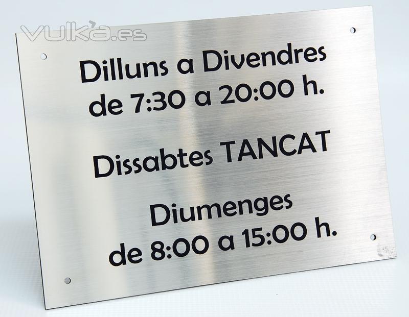 Placa de horario, con las esquinas taladradas para facilitar su colocación.