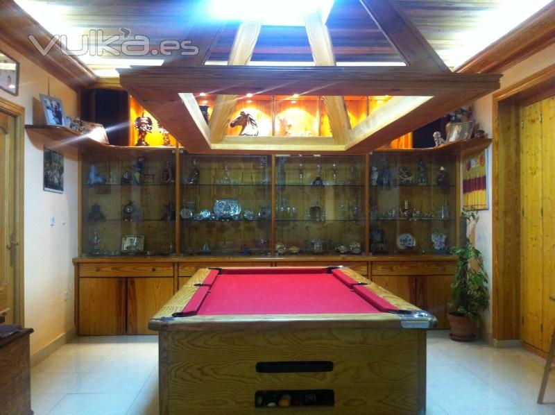 Mueble del fondo de madera, forrado de ventanas antiguas con friso madera y saneado de vigas vistas