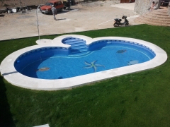 Piscina con escalera central con piedra en situ