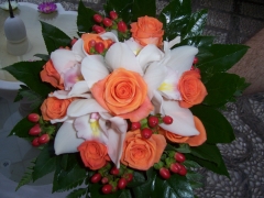 Ramo de novia compuesto de rosas naranjas y cymbidium.