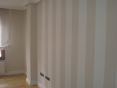Una pared a rayas verticales en el salon tostado y blanco roto