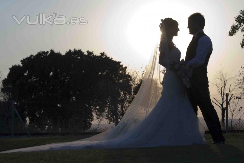 Novios posando a la puesta del sol.