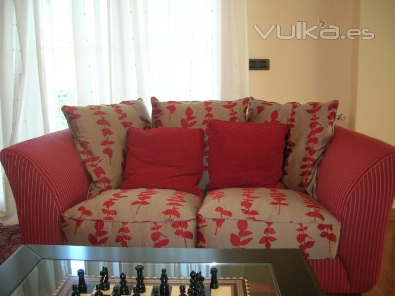 Sofa tapizado combinado y visillos con lunares.