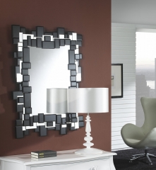 Espejo realizado con cristal negro y espejos biselados colocados asimtricamente a modo de marco.