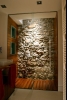 Ducha de bao con pared de piedra y forrado en madera