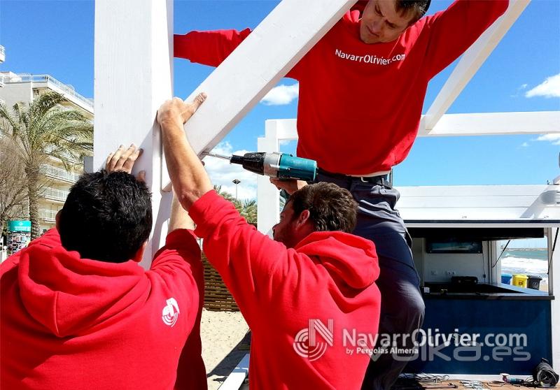 Montaje de pérgola de madera en color blanco. NevarrOlivier.com