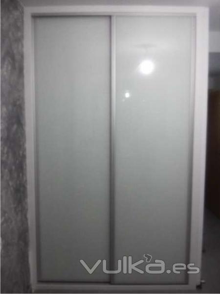 Frente de armario fabricado en cristal lacado blanco con perfilería aluminio plata mate
