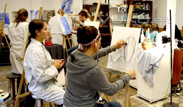 Students sketch various objects including vases and the human body during their art studio class.