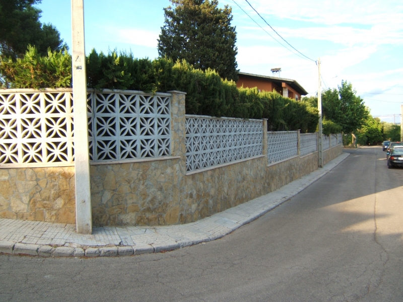 Construcción de muro forrado en piedra alrededor de chalet unifamiliar