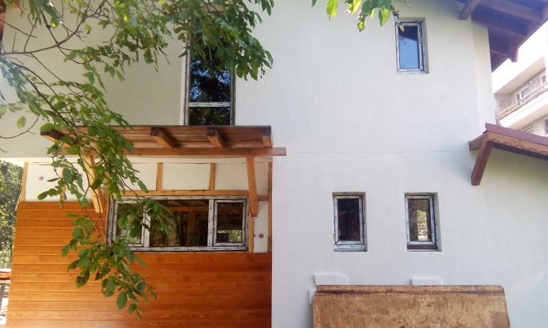 Aislamiento trmico de EPS,revocado de mortero en color blanco y detalles de madera en la fachada.