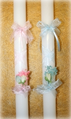 Vela de bautizo blanca, decorada con una cinta cruzada rosa o azul, dos lazos con una perla blanca y