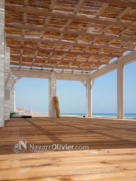 Terraza con suelo tratado en autoclave y pergola de madera con cubierta de mimbre