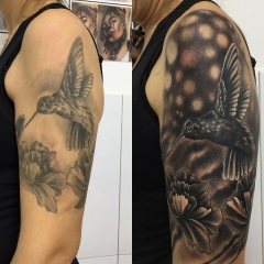 Tatuaje realista arreglo de colibr con flores