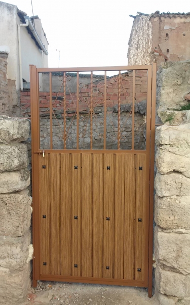 Puerta de cancela mixta: armazón de aluminio y lamas imitación madera, reja superior.