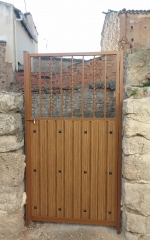 Puerta de cancela mixta: armazn de aluminio y lamas imitacin madera, reja superior.