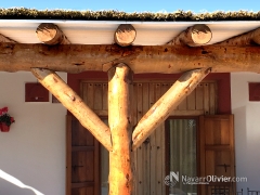 Detalle de construccion de pergola construida en tronco natural con cubierta de brezo