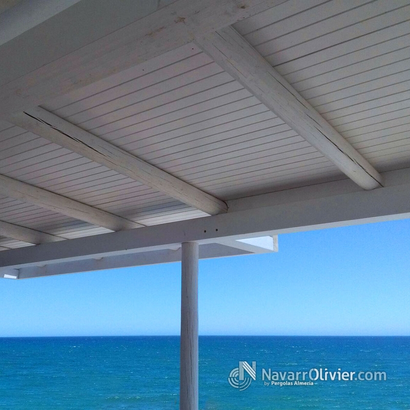 Pergola de madera y tronco calibrado acabada en blanco