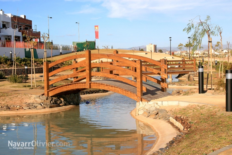 Puente de madera. Pasarela con plataforma en arco para zona ajardinada 