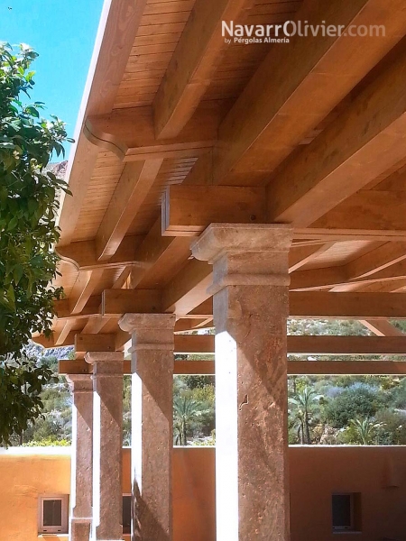 Pérgola de madera laminada sobre pilares de mármol travertino