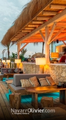 Terraza con pergola en madera y tronco cubierta por junco africano ( carritx)