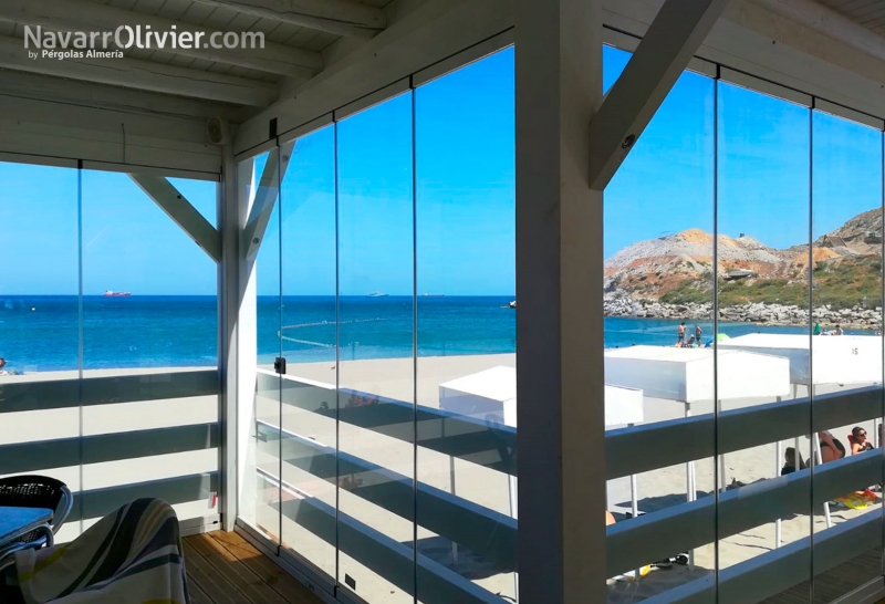 Terraza de madera para restaurante e playa con cerramiento de cristal