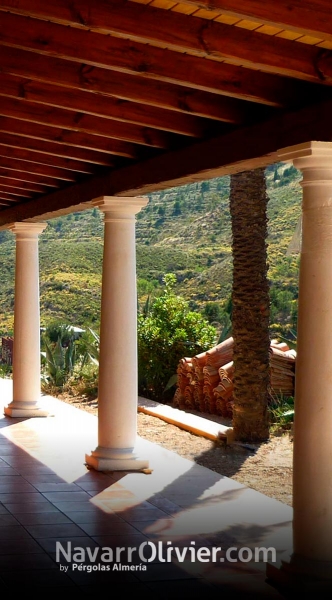 Elegante pérgola rústica para cortijo con pilares de cemento y cubierta en madera envejacida