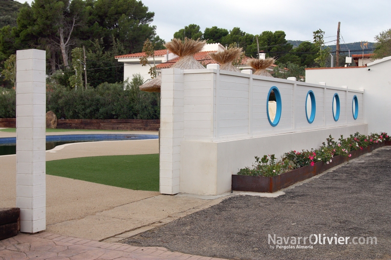 Muro en madera para exterior acabada en blanco con aberturas circulares