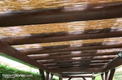 Pergola con cubierta de canizo construida en madera laminada y palo redondo