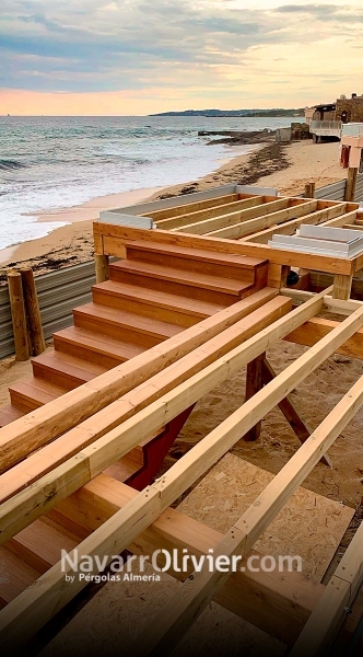 Construcción de terraza elevada sobre pilotes con escalera de iroko