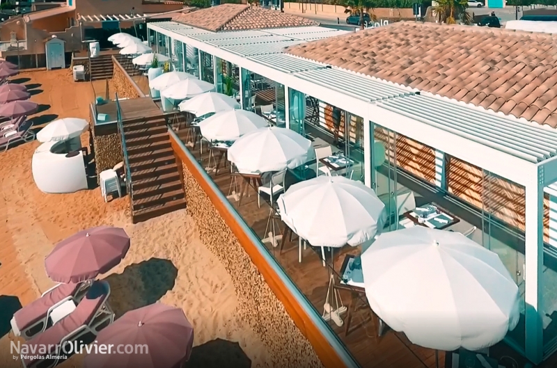 Construcción de club de playa con terraza sobre pilotes y cubierta bioclimatica