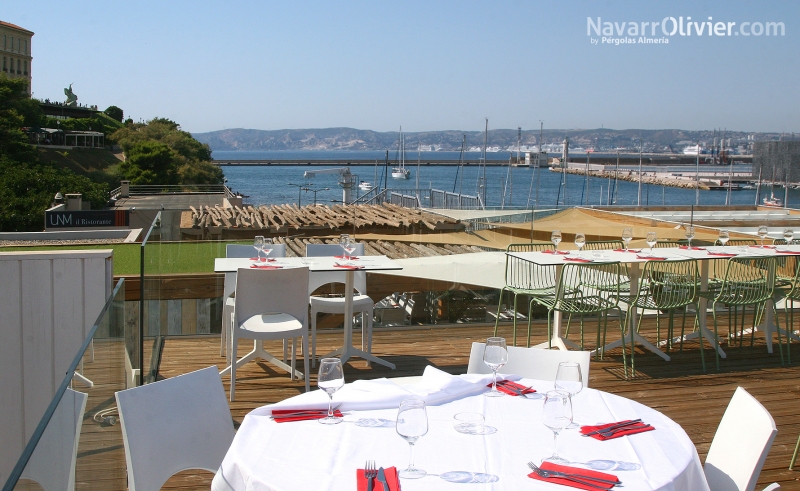 Terraza para restaurante con deck en tarima autoclave y barandilla de cristal laminado