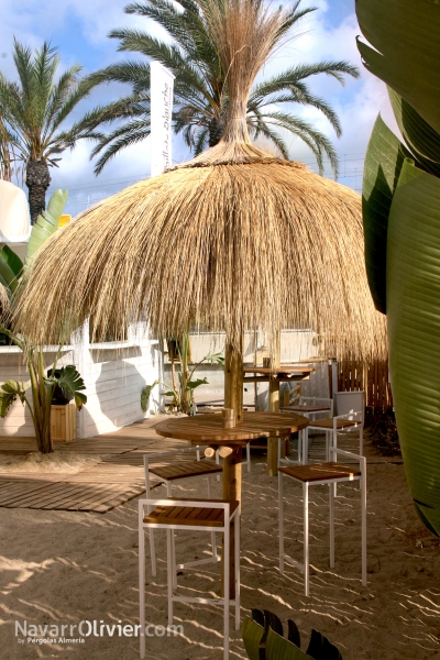 Terraza de beach club con sombrillas de carritx natural