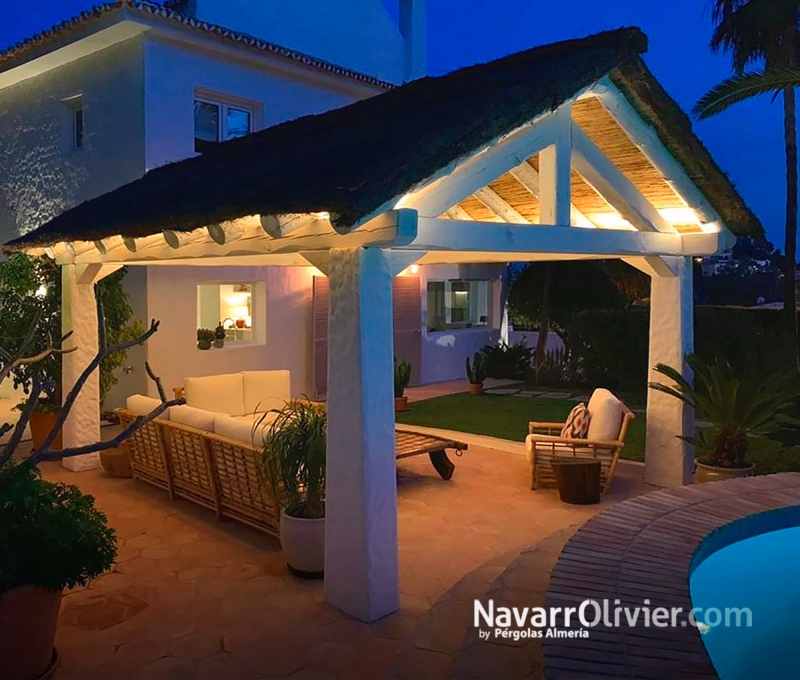 Pérgola para espacio de ocio en exterior de vivienda construida en madera reciclada y tronco 