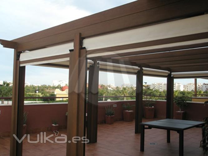 Pergola imitacin madera con toldo de palillera en la parte superior y bajantes a todo el contorno.