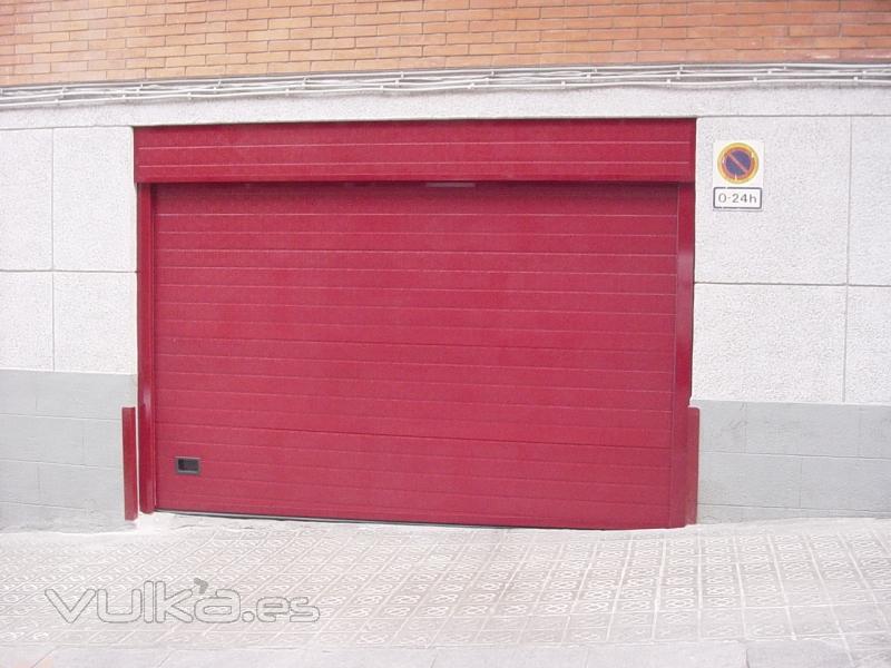 Puerta seccional lacada en rojo.